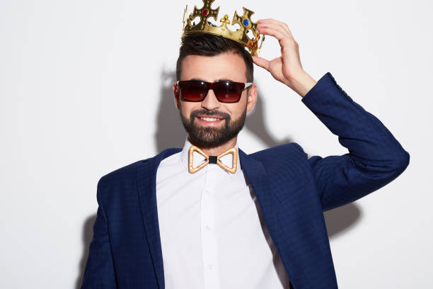 istock handsome man at white background wearing crown 905606156