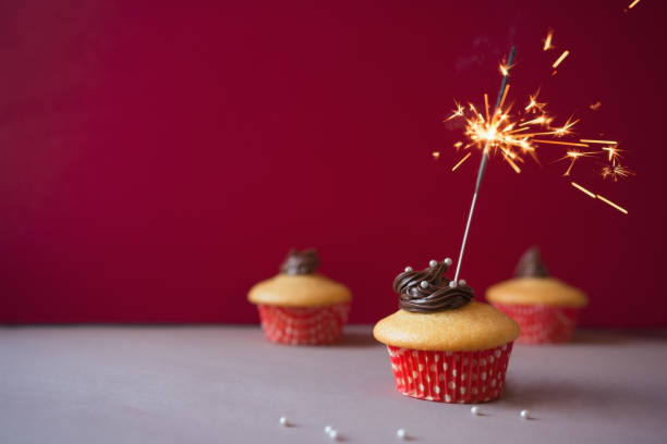 istock Anniversary cupcakes with party fireworks 905616782
