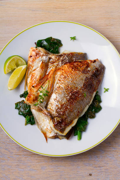 istock Dorado or dorada fish fillet with spinach, thyme and lime 905617286