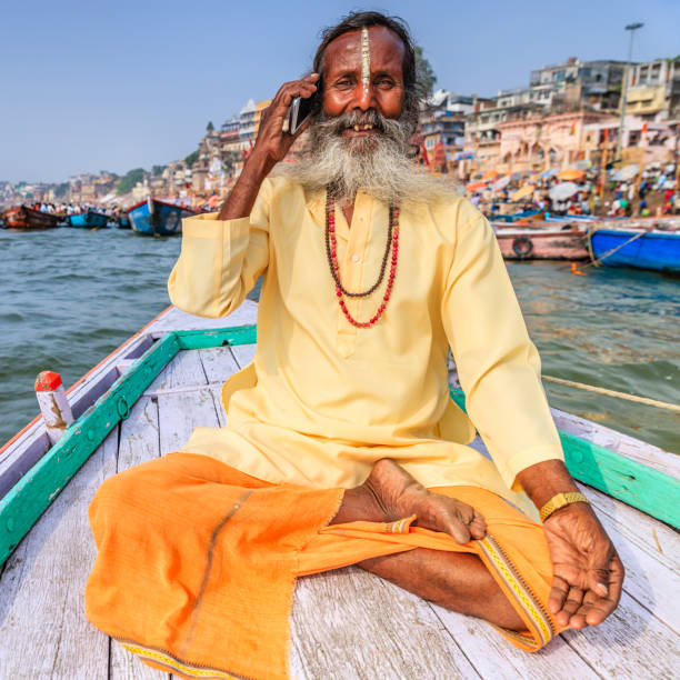 istock Sadhu using mobile in boat on Holy Ganges River, Varanasi 905619352