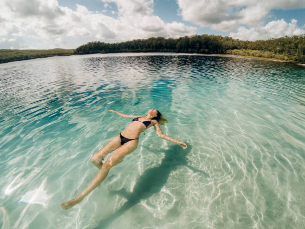 Relaxing in the Sea A young woman relaxes in the sea at Great Sandy National Park. fraser island stock pictures, royalty-free photos & images