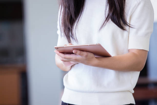 istock Asian woman using tablet with blurry background 905623920