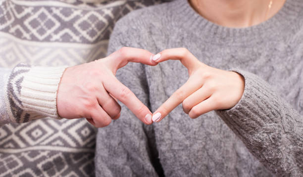 istock Closeup of couple making heart shape with hands 905626726