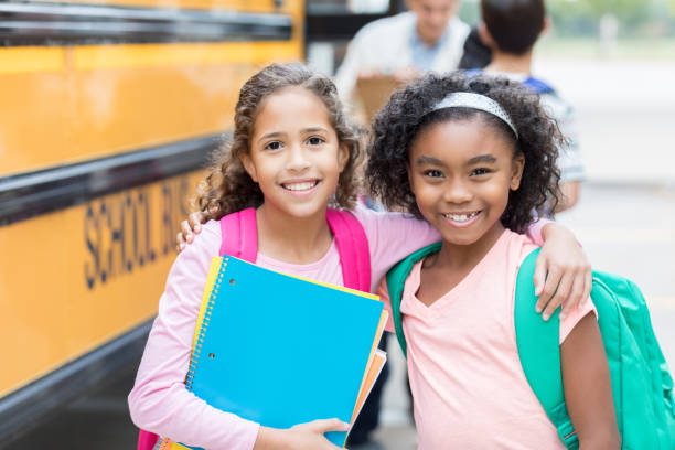 Two schoolgirls smile for camera on first day