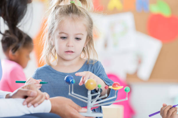 istock Little girl learns about planets in preschool class 905636712