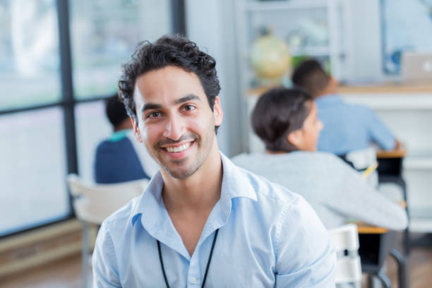 istock Young man smiles proudly in his middle school classroom 905637344