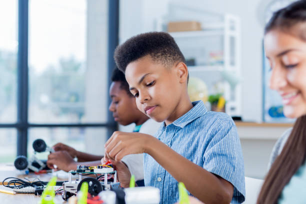 istock Preteen boy works on robotics project at school 905637356
