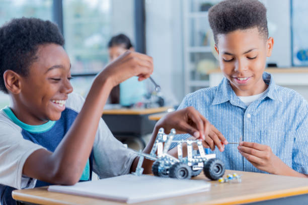 istock Two preteen boys work on robotics project together at school 905637360