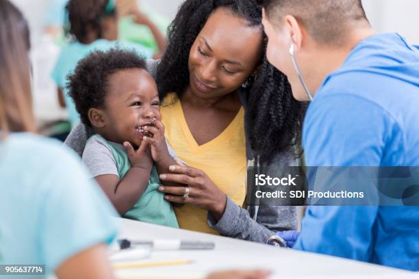 Photo libre de droit de Mâle Pédiatre Examine Le Bébé Garçon Dans Une Clinique Gratuite banque d'images et plus d'images libres de droit de Docteur