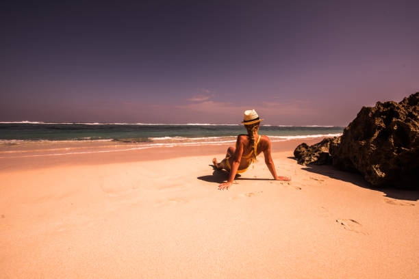 istock Young woman sitting on the beach. 905648712
