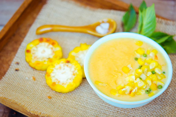 Vegetarian corn cream soup in the bowl on the rustic table
