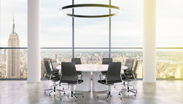 istock Office interior with large round desk and chairs with view at Empire state building 905659984