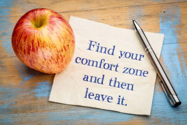 Find your comfort zome and then leave it - inspirational handwriting on a napkin with a fresh apple