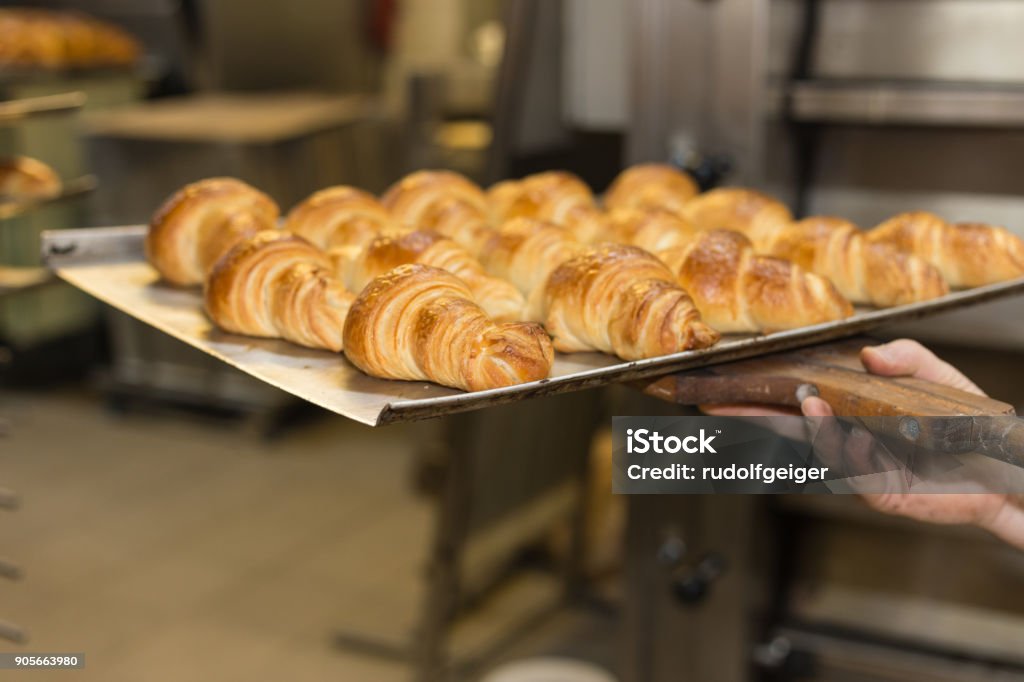 baking pastries and bread in an oven at a bakery baking pastries and bread in an oven with gold brown delicious colors at a bakery in south germany Bagel Stock Photo