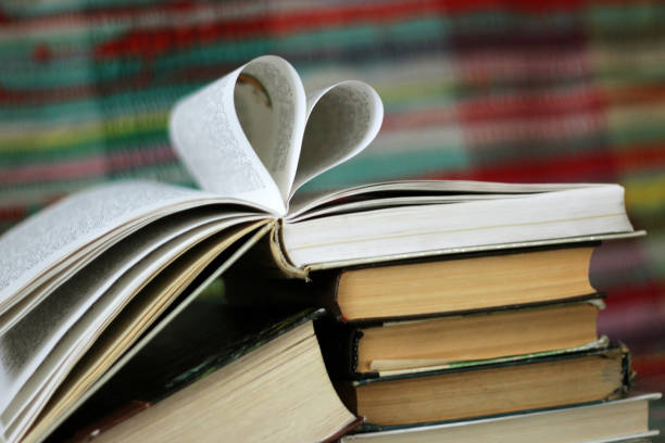istock Opened book with heart shaped pages on colourful background 905671482