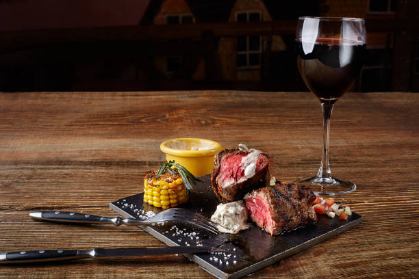 bife de churrasco com um copo de vinho tinto como o close-up de placa preta sobre fundo de madeira - scotch steak - fotografias e filmes do acervo