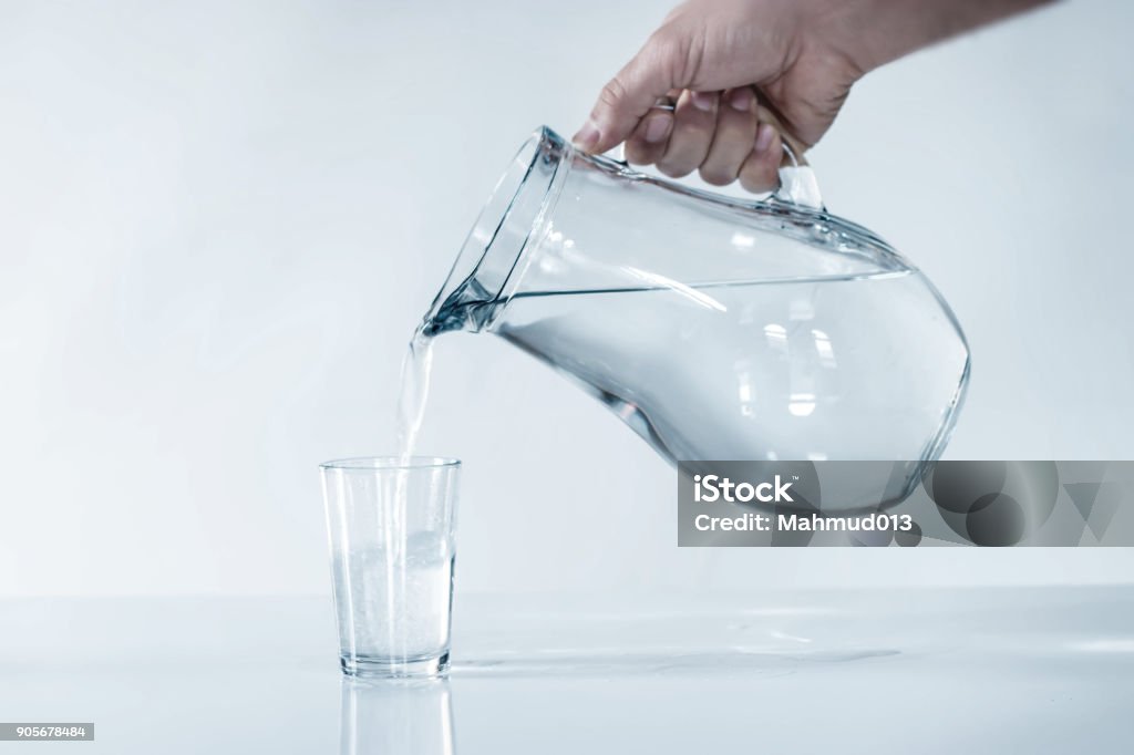 el hombre llena la taza de agua. DRİNK AGUA. - Foto de stock de Beber libre de derechos