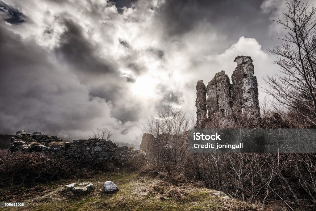 Ancient stone ruins of a fort at Vizzavona in Corsica Sun breaking through clouds onto the ancient stone ruins of a fort at Vizzavona in Corsica under dramatic dark moody skies Abandoned Stock Photo