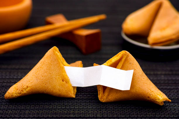 istock Fortune cookie with clear blank paper strip, another cookie and chopsticks on black napkin background. 905686584
