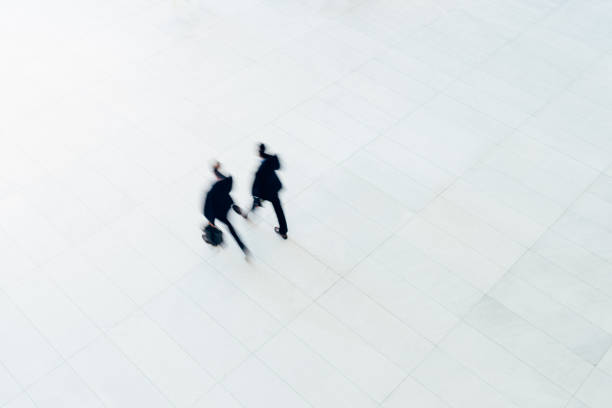 Overhead view of two businessman walking Overhead view of two businessman walking on large empty office. obscured face photos stock pictures, royalty-free photos & images