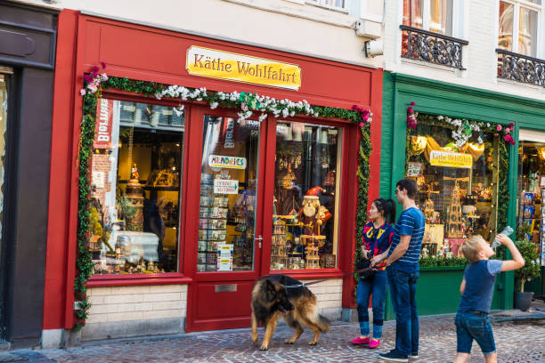 Bruges, Belgium, - August 31, 2017: Souvenir store with a young couple walking their dog and a child drinks water in the medieval city of Bruges, Belgium
