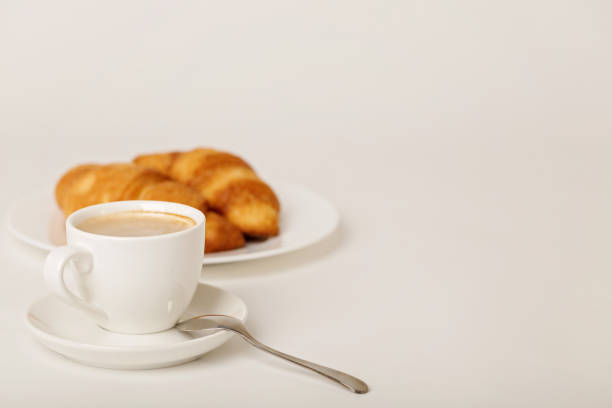 Breakfast - coffee with croissants on a white background. Selective focus.