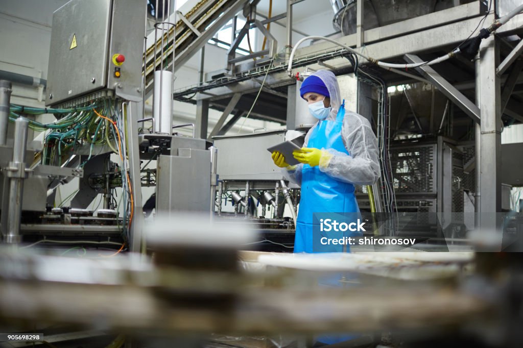 Worker with tablet Seafood factory worker with touchpad reading online information or comments of consumers about their products Food Processing Plant Stock Photo