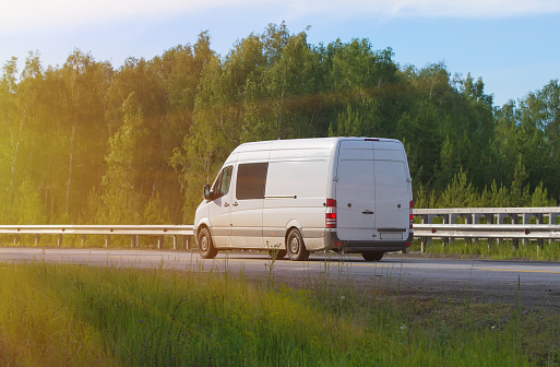 minibus goes on the country highway along the wood