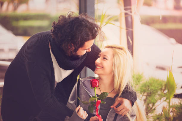 istock Smiling couple outdoors with red rose 905699384