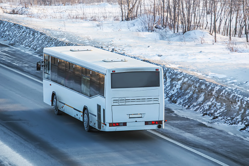 bus is driving on a country road in winter