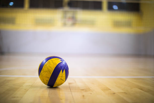 ein volleyball-ball auf einem hölzernen turnhalle boden - volleyball sport floor ball stock-fotos und bilder