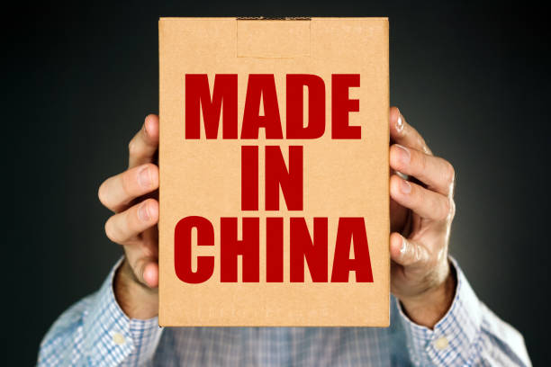 istock Man holding cardboard box product package with Made in China 905703358