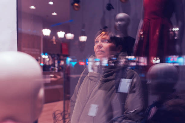 istock Thoughtful woman looking through shop window 905703800