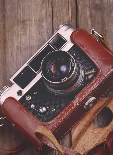 istock Retro camera on the uneven wooden background 905704190