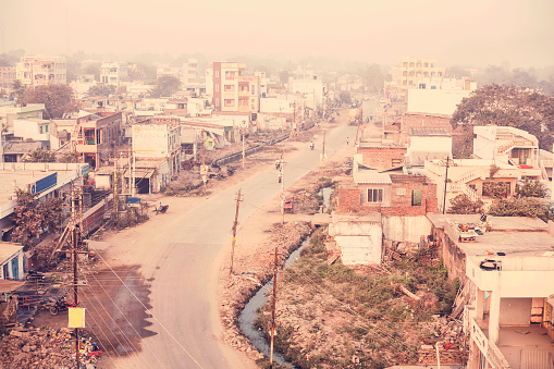 Gurazala, Andhra Pradesh in Southeastern India.  The poverty stricken area is located in the Guntur district.  Residential and abandoned buildings under a foggy sky.  No people.