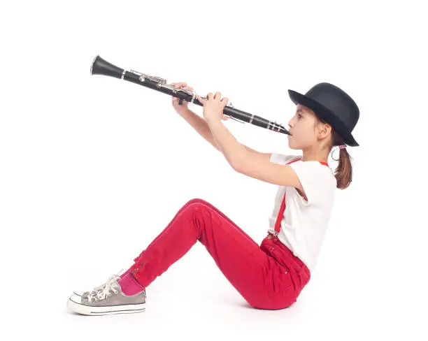 little girl playing clarinet on a white background