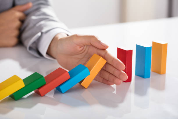 istock Businessperson Hand Stopping Colorful Blocks From Falling 905715592