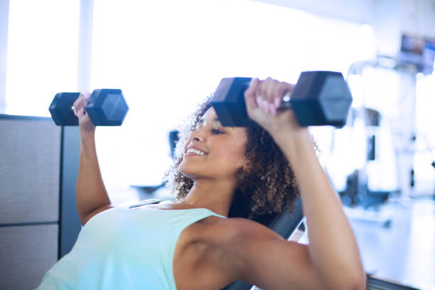 istock Young Woman Weightraining at the Gym 905715980