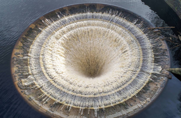 Viewed from above a drain hole on Ladybower reservior in full flow following a period of heavy rain and melting snow.