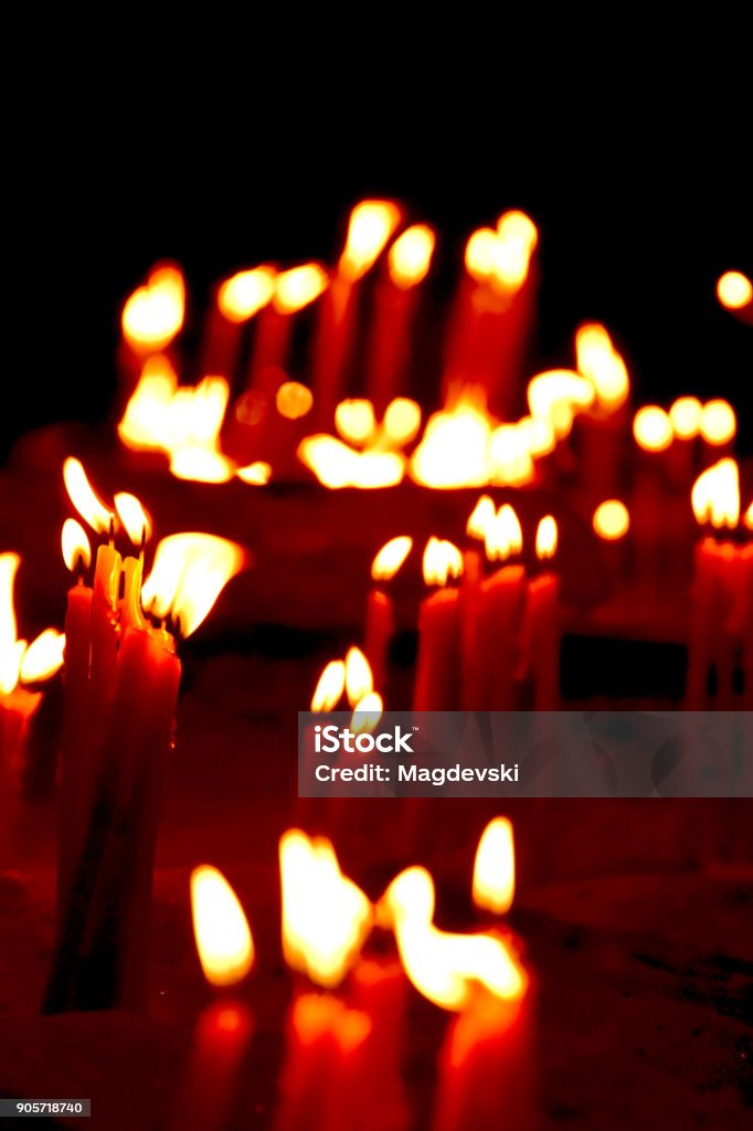 burning candles on a candle stand in the church Ancient Stock Photo