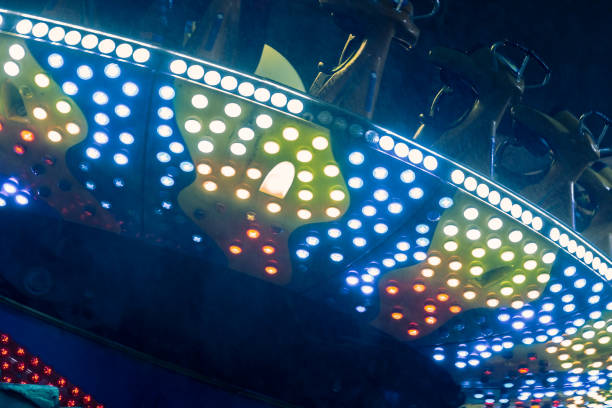 istock Amusement park at night - carousels and attractions in motion 905719716