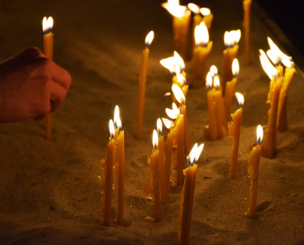 istock People burn candles in the church 905721972