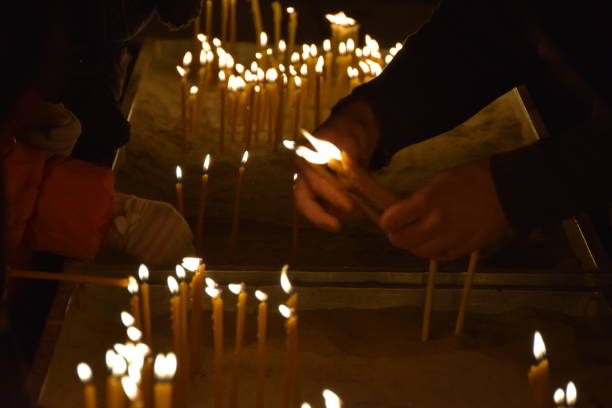istock People burn candles in the church 905721984