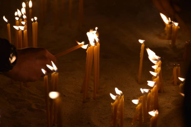 istock People burn candles in the church 905722028
