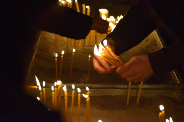 istock People burn candles in the church 905722198