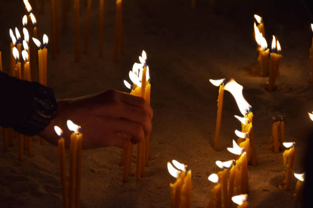 istock People burn candles in the church 905722732