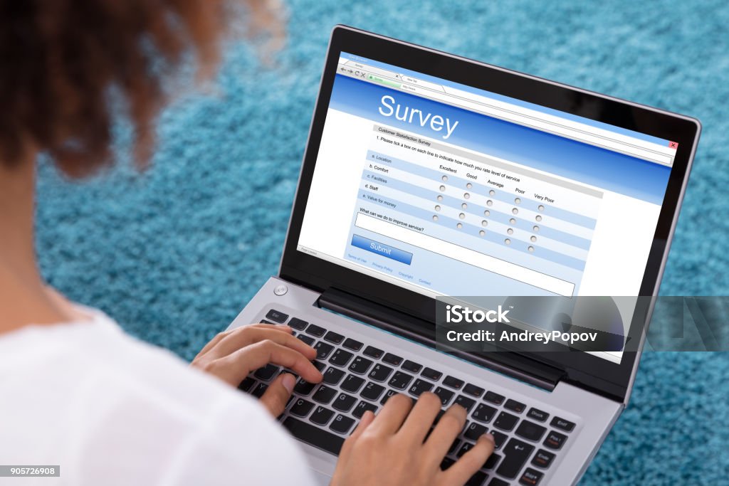 Woman Filling Survey Form On Laptop Close-up Of A Woman's Hand Filling Survey Form On Laptop Questionnaire Stock Photo