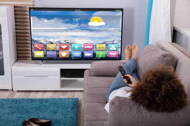 istock Woman Watching Television With Colorful Applications On Screen 905726940