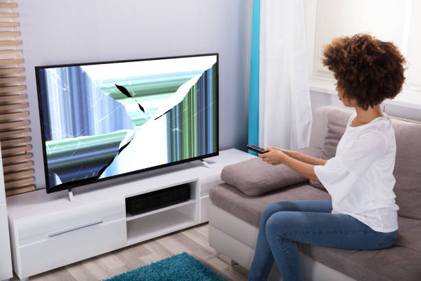 istock Woman Sitting Near Television Showing Distorted Screen 905726962