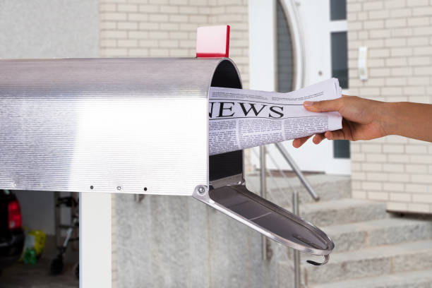 istock Person Removing Newspaper From Mailbox 905726978